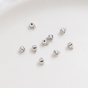 Vista macro dettagliata di perle distanziatrici in argento lucido 14k su vassoio ceramico