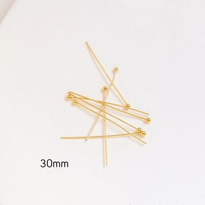 Macro view of 30mm golden ball head pins for jewelry making and DIY crafts