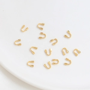 Vista macro de protectores de hilo en forma de U bañados en oro de 14k para joyería