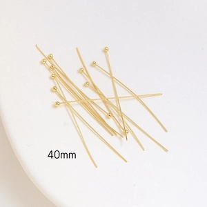 Macro view of 40mm gold ball head pins for DIY jewelry making with metallic finish