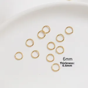 Detail view of 6mm gold-plated open jump rings with 0.6mm thickness on a white tray