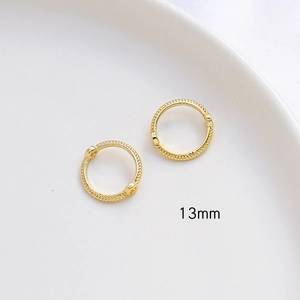 Vista macro de aros dorados de 13mm con textura trenzada para joyería artesanal