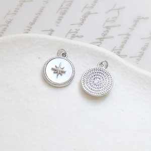 Macro detail of gold-plated rose shell charms with star inlay and spiral texture