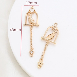 Detail of gold-plated birdcage charms with zircon stars, measuring 17mm by 43mm