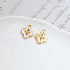 Detailed macro of gold plated four-leaf clover pendants with enamel inlay and zircon