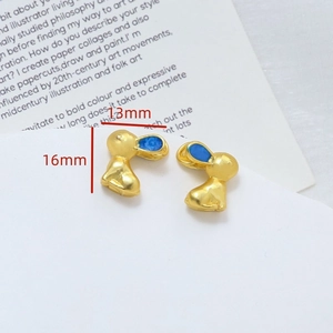 Dettaglio di ciondoli a forma di coniglio in smalto dorato con orecchie blu, 16x13 mm