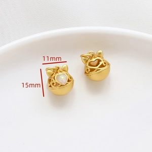 Primer plano de dije de campana de gato dorado con opale de corazón y medida 15mm