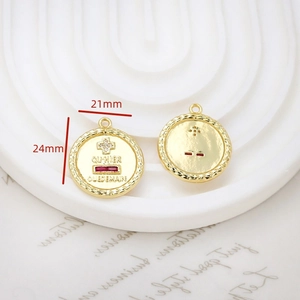 Macro detail of gold plated cross pendant with red zircon and French engraving text