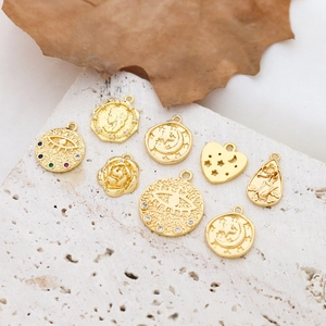 Gold-plated vintage pendants with cubic zirconia and floral embossing on white stone base