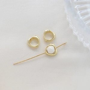 Detailed view of gold-plated heart frames with pearls for DIY jewelry making