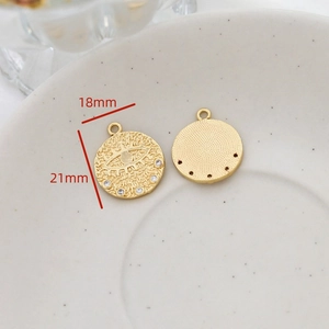 Detail of evil eye pendant charms in gold plated brass with dimensions 18mm by 21mm