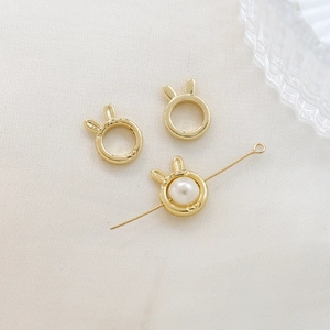 Detail of rabbit ear gold bead frame with white pearl for DIY jewelry making