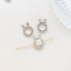 Detail of silver bunny ear bead charms with white pearl inlay for DIY jewelry making