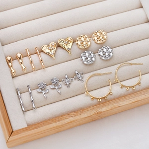 Assorted gold and silver DIY jewelry charms with zircon accents on velvet tray
