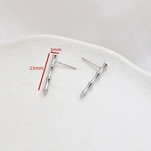 Detailed view of silver bamboo-style stud earrings with 23mm length measurements