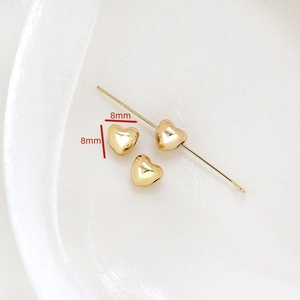 Détail macro de perles coeur dorées 8mm avec finition polie pour bijoux DIY