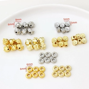 Macro view of gold-plated flower-shaped spacer beads in various sizes for jewelry making