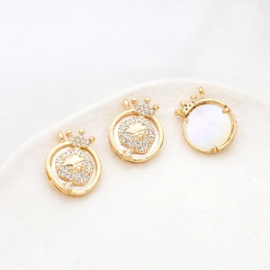 Detail of gold-plated Leo lion head pendants with mother of pearl and zircon stones