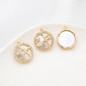 Macro detail of gold plated Sagittarius zodiac pendants with shell inlay and zircons
