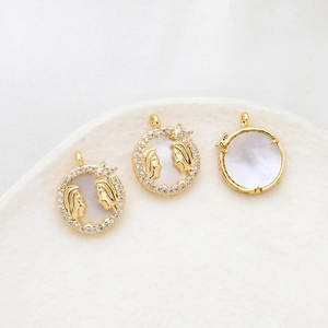 Macro shot of gold-plated zodiac charms featuring mother of pearl inlay and zircon borders