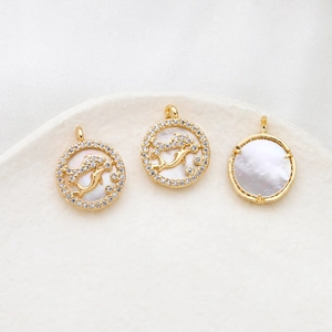 Macro shot of gold-plated dolphin pendants with mother of pearl and sparkling crystals