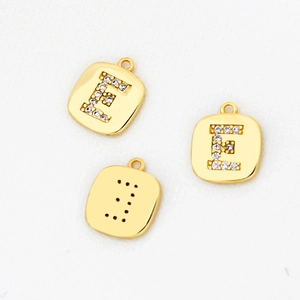 Detail eines vergoldeten Buchstabe-E-Anhängers mit weißen Zirkonia-Steinen für Schmuck