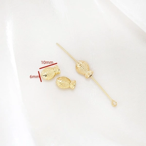 Détail macro de perles d'espacement en forme de poisson dorées 14K de 10 mm pour bijoux