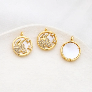 Macro detail of Taurus zodiac pendants with gold plating and white shell texture