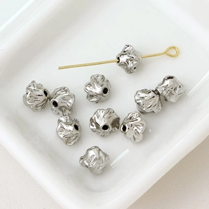 Detailed view of silver irregular flower beads for DIY jewelry with center hole