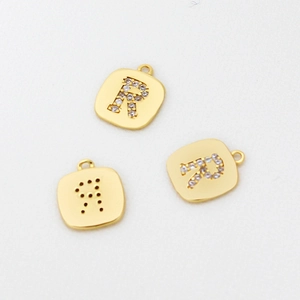 Detailansicht goldener quadratischer Anhänger mit Buchstabe R aus Zirkonia und Cut-Out