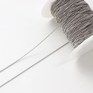 Détail d'une chaîne à billes argentée sur bobine pour accessoires de bijoux DIY