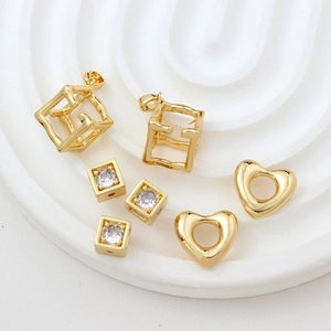 Macro view of 18k gold plated hollow cube heart pendants and zircon square spacer beads