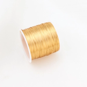 Close-up of 14K gold filled craft wire on a white plastic spool for DIY jewelry making