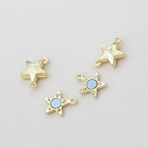 Détail de fermoirs magnétiques en forme d'étoile dorée avec incrustation bleue et boucles