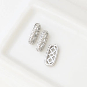 Macro detail of three silver plated square spacer beads with cubic zirconia for jewelry making