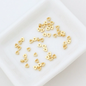 Makroaufnahme von 18k vergoldeten Dreiecks-Abstandshalterperlen für DIY-Schmuck