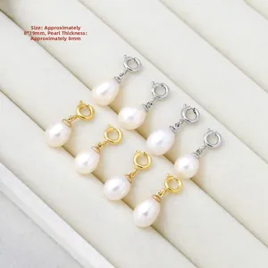 Macro detail of 8x19mm teardrop freshwater pearl pendants with gold and silver spring clasps