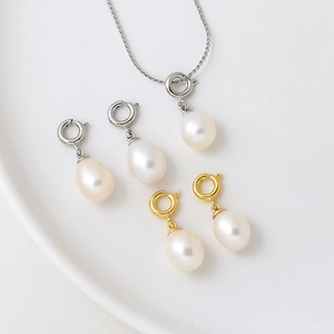 18K freshwater pearl charm pendant with gold and silver lobster clasps on white ceramic