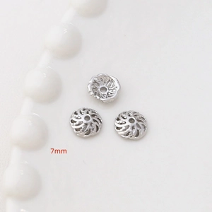 Dettaglio macro di distanziatori a fiore cavo da 7mm argento per creazione gioielli