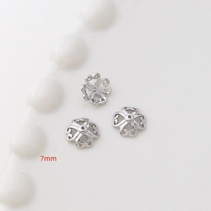 Dettaglio macro di tre coppette per perline a fiore argento da 7mm per gioielli
