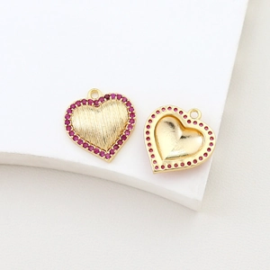 Detail view of heart pendants in gold plated copper with pink cubic zirconia stones