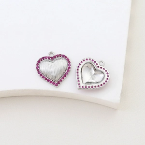 Macro detail of heart-shaped pendants with pink zircon stones for DIY jewelry making