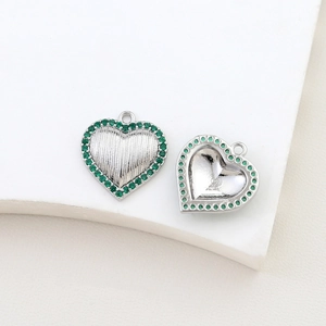 Detailed close-up of heart charm with green zircons and silver textured finish for DIY