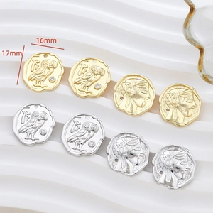 Macro detail of 16mm gold and silver coin pendants with owl and portrait relief