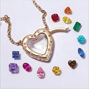 Collar con colgante de corazón dorado y gemas de colores sobre fondo blanco liso