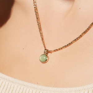 Dettaglio di una collana a catena Figaro placcata oro 14K con pendente in avventurina verde