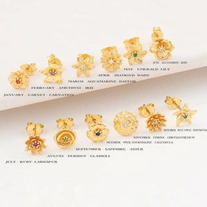 Detalle de 12 pendientes de flores de nacimiento bañados en oro con piedras