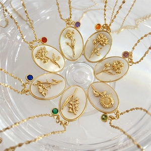 Detalle macro de collares bañados en oro de 18K con colgantes de nácar y piedras preciosas
