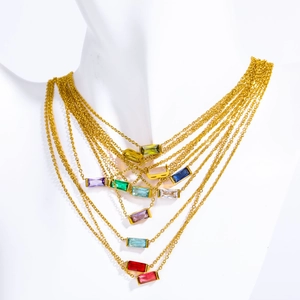 Close-up of golden necklaces set with colorful rectangular baguette cubic zirconia stones