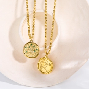 Detailed close-up of vintage gold Medusa and goddess coin pendants on layered necklaces